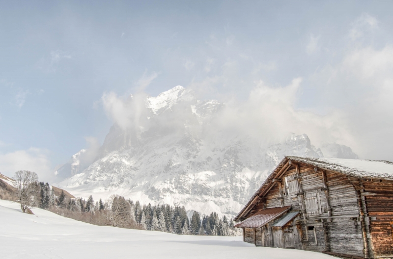 Wooden Cottage in Swiss mountains with winter landscape